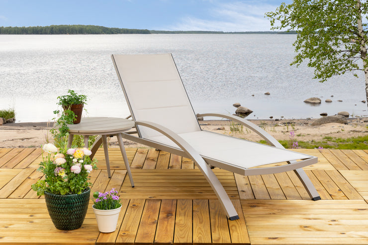 Kuvassa on beige Suvi-sohvapöytä Suvi Textiline -aurinkotuolin kanssa.